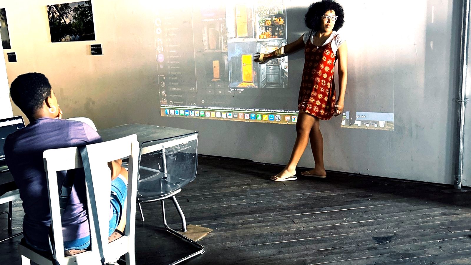 Laila Jhané presenting AI film editing on the projection screen during the Frames of the Future workshop at Eyedrum.